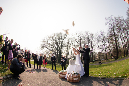 weie Hochzeitstaube steigt jeweils aus den Hnden des Brautpaares empor